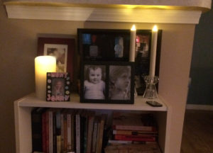 Three Luminara candles flickering on a bookcase