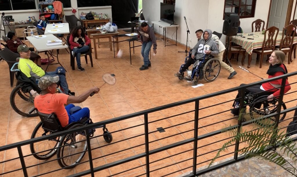 Four wheelchair users playing badminton.